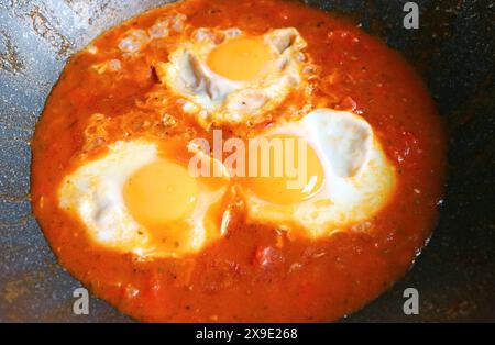 Nahaufnahme von Eiern, die in gewürzter Tomatensauce für Shakshuka-Gericht pochiert wurden Stockfoto