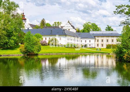 Ein malerischer Blick auf das Schloss Velke Losiny in Tschechien, mit dem wunderschönen weißen Gebäude, das sich in einem ruhigen Teich spiegelt, umgeben von üppigem Grün. Stockfoto