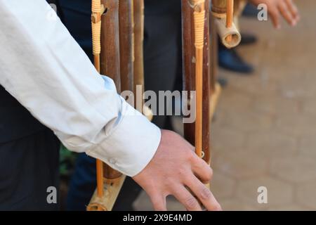 Bandung, 17. August 2019. Eine Hand eines Jungen, der auf einer lokalen Hochzeit 'Angklung' spielt. Angklung ist als traditionelles Musikinstrument beliebt. Stockfoto