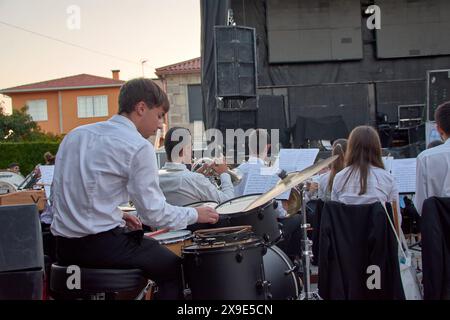 Eine Gruppe klassischer Musiker tritt live bei einem Abendkonzert im Freien auf, wobei der Schwerpunkt auf einem Schlagzeuger im Vordergrund liegt Stockfoto