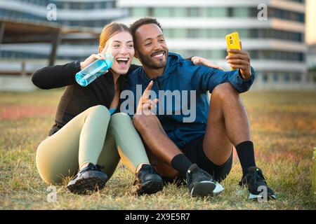 Junge Athleten lächeln und machen ein Selfie während der Trainingspause im Freien. Stockfoto