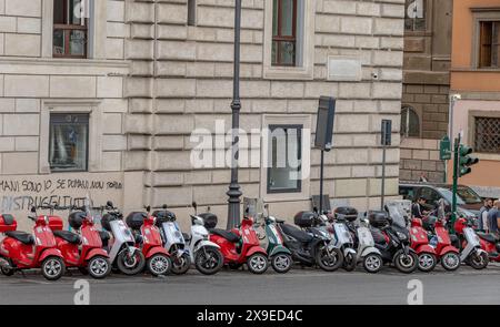 Eine Reihe von Mopeds/Motorrollern parkt auf der Via di S Maggiore in Rom, Italien Stockfoto