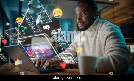Afroamerikanischer Projektmanager, der am Computer im Büro arbeitet. Augmented Reality Social Media-Symbole werden auf dem Laptop des Mitarbeiters angezeigt. Internet der Dinge, Konnektivität und Online-Konzept. Stockfoto