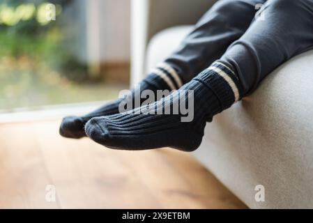 Blick auf Kinderfüße in warmen Stricksocken. Warmes Winterkonzept. Stockfoto