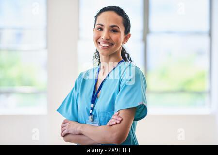 Selbstbewusste Ärztin stehend mit gekreuzten Armen im Krankenhaus Stockfoto