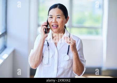 Selbstbewusste Ärztin telefoniert im Krankenhaus Stockfoto