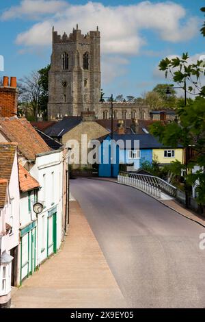 Farbenfrohe Cottages rund um die Ballingdon Bridge über den Fluss Stour in Sudbury, Suffolk, England, mit All Saints Parish Church im Hintergrund Stockfoto