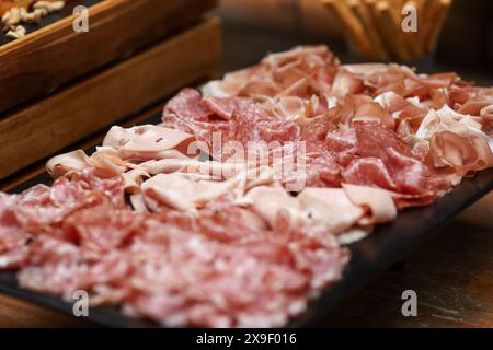 Geringe Schärfentiefe (selektiver Fokus) mit verschiedenen Fleischsorten (Wurstwaren) an einem Buffet. Stockfoto