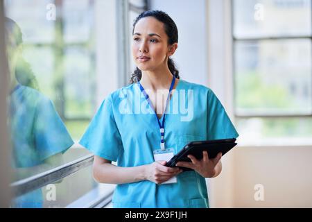 Professionelle weibliche Krankenschwester in Scrubs mit Digital Tablet im Krankenhaus Stockfoto