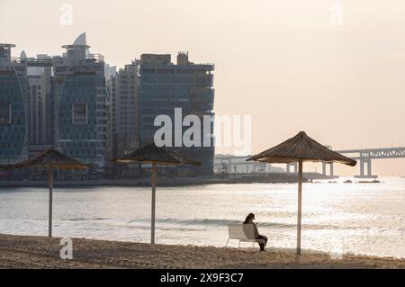 Frau sitzt am Gwangalli Beach, Busan, Südkorea Stockfoto