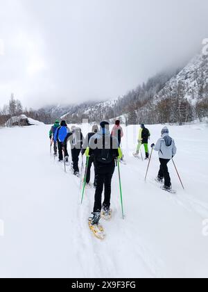 Eine Gruppe von Schneeschuhwanderungen im schneebedeckten Tal Stockfoto