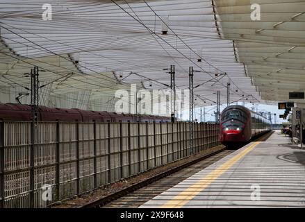 Der Hochgeschwindigkeitszug fährt in den Bahnhof Reggio Emilia AV Mediopadana ein, der in Italien fortgeschrittene Eisenbahnverkehr ist. Stockfoto