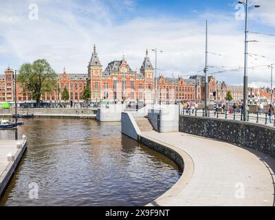 Der Wasserweg und die Böschungen vor dem belebten Hauptbahnhof Amsterdam Centraal wurden am 27. Mai 2024 in der Hauptstadt der Niederlande gesehen. Stockfoto