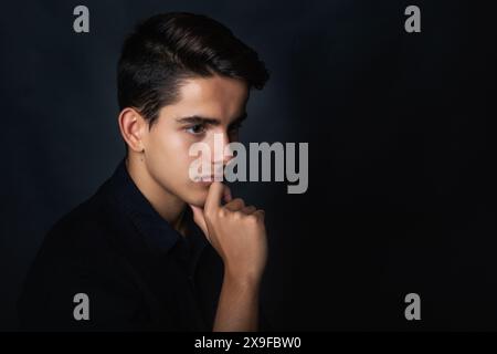 Profilporträt eines gutaussehenden jungen Mannes mit der Hand am Kinn Stockfoto