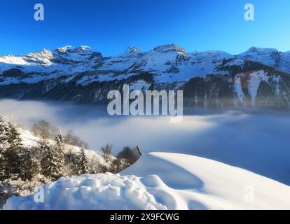 Aus der Vogelperspektive der niedrigen Wolke über einer schneebedeckten alpinen Landschaft, Klausenpass, Schweiz Stockfoto