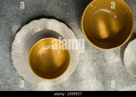 Blick von oben auf vier leere Keramikplatten und -Schüsseln auf einem Tisch Stockfoto
