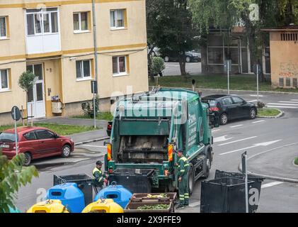 Sibiu City, Rumänien - 29. Mai 2024. Arbeiter, die Müllcontainer mit Müll ausziehen, Straßenreinigung, Männer, die Abfall aus Mülltonnen laden Stockfoto