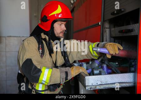 Feuerwehrmann in Uniform mit Feuerwehrausrüstung auf der Station Stockfoto