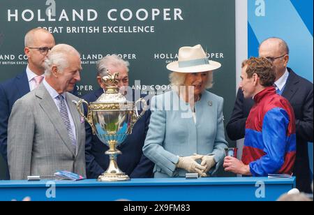 Epsom, Großbritannien. 31. Mai 2024. König Charles III. Und Königin Camilla mit dem Krönungspokal und Jockey Ryan Moore. Ladies Day in Epsom. Stürmische Bedingungen am ersten Renntag in Epsom. Das große Rennen des Tages ist die Oaks um 4,30 Uhr. Das Derby geht morgen. Quelle: Mark Thomas/Alamy Live News Stockfoto