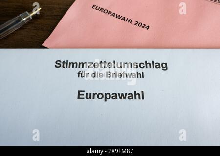 Briefumschlag für die Europawahlen 2024 (Europawahl). Postalische Wahldokumente in Deutschland. Rosafarbener Briefumschlag und ein Stift. Stockfoto