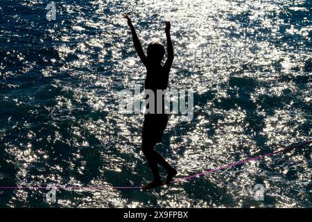 Slack-Line-Künstler in dramatischer Landschaft Stockfoto