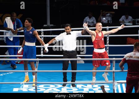 Bangkok, Thailand. 31. Mai 2024. Damian Durkacz (Rot) aus Polen feiert nach dem Sieg über Jorge Cuellar (Blau) aus Kuba während des 2. World Qualification Turniers in Paris im Indoor Stadium Huamark. Damian Durkacz aus Polen erhielt bei den Olympischen Spielen 2024 in Paris eine Quote von 71 kg, nachdem er Jorge Cuellar aus Kuba gewonnen hatte. Quelle: SOPA Images Limited/Alamy Live News Stockfoto