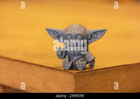 Madrid, Spanien 7. Mai 2024 DIN Grogu, Star Wars Spielzeugheld aus recyceltem Kunststoff isoliert auf gelbem Hintergrund. Happy Baby Yoda aus der Disney-Serie. Stockfoto