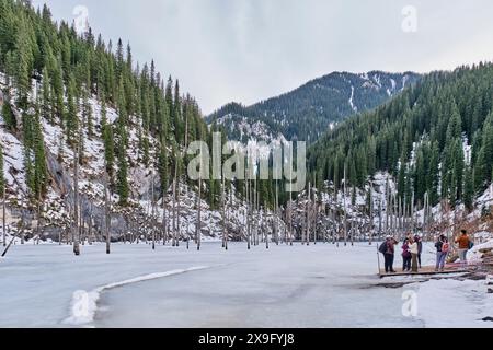 Almaty, Kasachstan - 19. März 2024: Kaindy-See, mit Eis bedeckt, Naturdenkmal in der Nähe von Almaty, Kasachstan. Fichtenbäume ragen aus Eis. Gruppe Stockfoto