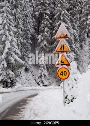 Straßenschilder. Bergstraße im Wald bei Schneefall Stockfoto