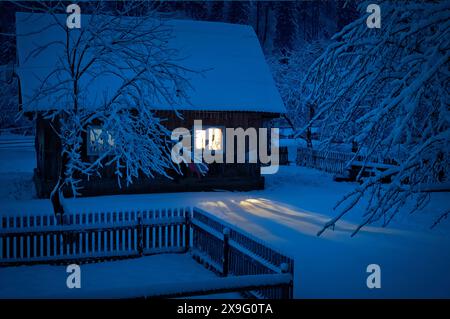 Altes Haus bedeckt mit Schnee am Abend Stockfoto