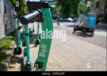 Reihen grüner Elektroroller, die auf einem Bürgersteig der Stadt geparkt sind. Mietfahrzeuge für den Personenverkehr. Litauen Vilnius Stockfoto