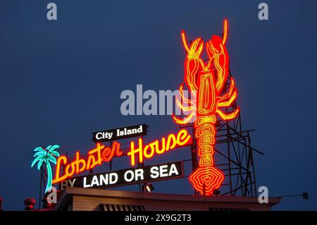 Ein neonheller Hummer hängt oben in einem Fischrestaurant auf City Island, New York, und lockt Gäste in das Café Stockfoto