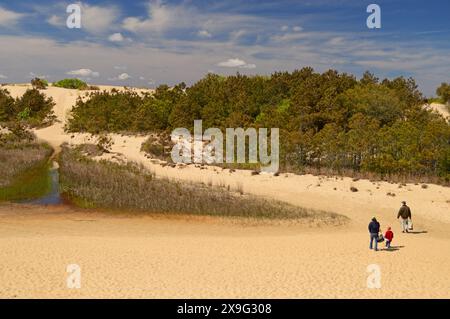 Eine Familie wird auf dem Weg entlang der großen Sandsonnen an den Outer Banks im Jockey Ridge State Park in der Nähe von Nags He kleinwütig Stockfoto