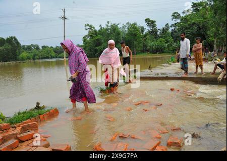 Die Dorfbewohner überqueren die Straße, die durch den Wasserfluss in Nayakhel im Gebiet von Goanghat upazila unterbrochen wurde, weil der Sturm Remal Bangladesch traf. Am 30. Mai 2024 in Sylhet, Bangladesch. (Kreditbild: © MD Rafayat Haque Khan/OKULARIS via ZUMA Press Wire) NUR REDAKTIONELLE VERWENDUNG! Nicht für kommerzielle ZWECKE! Stockfoto