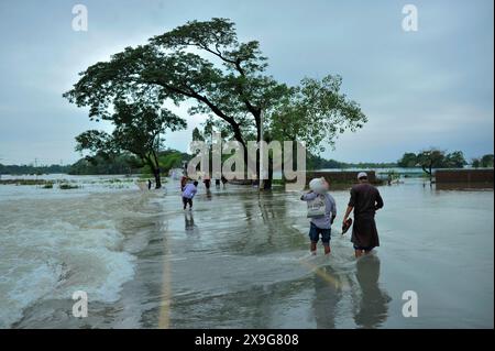 Sylhet, Bangladesch. 30. Mai 2024. Menschen, die aufgrund des starken Regens, nachdem der Zyklon Remal Bangladesch getroffen hatte, schwer durch die überflutete Hauptstraße des Lafnaut-Gebiets von Goanghat upazila zu waten sind. Am 30. Mai 2024 in Sylhet, Bangladesch. (Foto: MD Rafayat Haque Khan/Eyepix Group/SIPA USA) Credit: SIPA USA/Alamy Live News Stockfoto