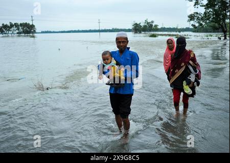 Sylhet, Bangladesch. 30. Mai 2024. Menschen, die aufgrund des starken Regens, nachdem der Zyklon Remal Bangladesch getroffen hatte, schwer durch die überflutete Hauptstraße des Lafnaut-Gebiets von Goanghat upazila zu waten sind. Am 30. Mai 2024 in Sylhet, Bangladesch. (Foto: MD Rafayat Haque Khan/Eyepix Group/SIPA USA) Credit: SIPA USA/Alamy Live News Stockfoto