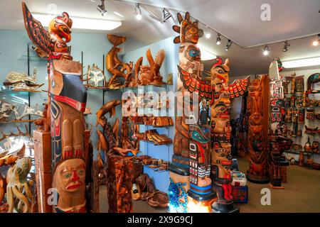 Holzstatuen, Totempfähle und andere einheimische Kunstwerke im Rain Barrel Souvenirladen in Ketchikan, Alaska Stockfoto