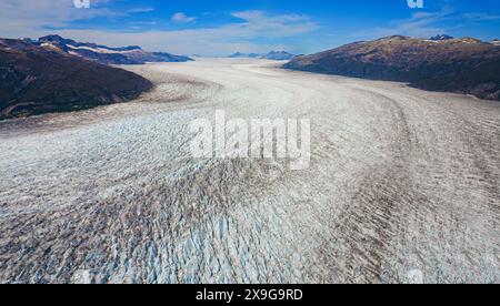 Aus der Vogelperspektive auf die Gletscher entlang des Taku Inlet, die Teil des Juneau Icefield in Alaska, USA sind - kurviger Eisstrom bedeckt mit Scherung Stockfoto