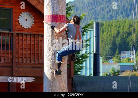 Holzfäller klettern auf einen Baumstamm während der Great Alaskan Lumberjack Show in Ketchikan, Alaska - beliebte Touristenattraktion, wo Holzfäller konkurrieren Stockfoto