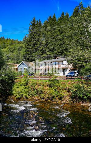 Haus am Ufer des Ketchikan River, inmitten eines üppigen Fichten- und Kiefernwaldes in Ketchikan, Alaska Stockfoto