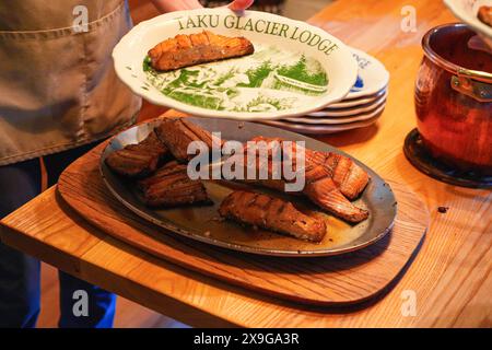 Teller mit gekochtem Lachsfilet im Blockhaus der Historic Taku Glacier Lodge, einer Holzhütte in den Bergen nördlich der Hauptstadt Alaskas Stockfoto