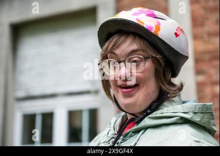 Außenporträt einer 41-Jährigen Frau mit Down-Syndrom, die draußen einen Fahrradhelm trägt, Tienen, Flandern, Belgien. Modell freigegeben. Stockfoto