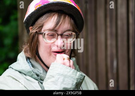 Außenporträt einer 41-Jährigen Frau mit Down-Syndrom, die draußen einen Fahrradhelm trägt, Tienen, Flandern, Belgien. Modell freigegeben. Stockfoto