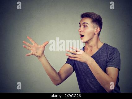 Junger Mann, der versucht, etwas zu fangen Stockfoto