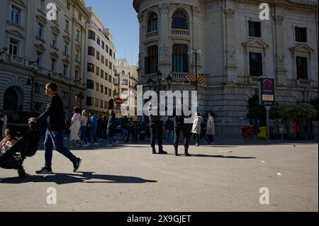 Während der Las fallas-Feierlichkeiten beobachten Polizeibeamte, wie die Menschen durch eine geschäftige Straße in Valencia spazieren Stockfoto