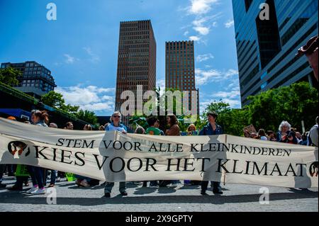 Amsterdam, Niederlande. 31. Mai 2024. Die Demonstranten halten ein großes Banner mit der Aufschrift „Wählen Sie das Klima während der Kundgebung aus“. Tausende von Menschen versammelten sich im Zentrum des Finanzzentrums der Niederlande in Amsterdam, um Milliarden an Subventionen für fossile Verschmutzer zu stoppen. Mehrere Klimaorganisationen wollen kurz vor den Europawahlen eine faire (Klima-)Politik fordern. (Foto: Ana Fernandez/SOPA Images/SIPA USA) Credit: SIPA USA/Alamy Live News Stockfoto