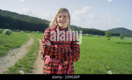 Porträt eines Wanderers, ein süßes lächelndes Mädchen mit Brille und Zahnspange in wunderschöner grüner Natur. Stockfoto