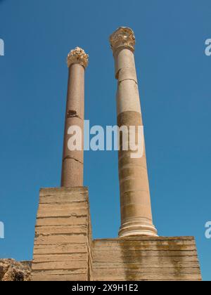 Zwei hohe alte Säulen vor einem klaren blauen Himmel, Teil einer Ruine, Tunis in Afrika mit Ruinen aus der römischen Zeit, modernen Moscheen und Stockfoto