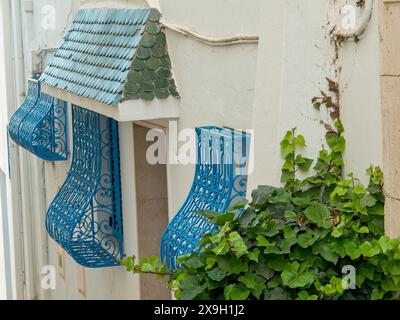 Weiße Gebäudewand mit dekorativen blauen Balkonen und grünen Dachziegeln, Tunis in Afrika mit Ruinen aus römischer Zeit, moderne Moscheen und blau und Stockfoto