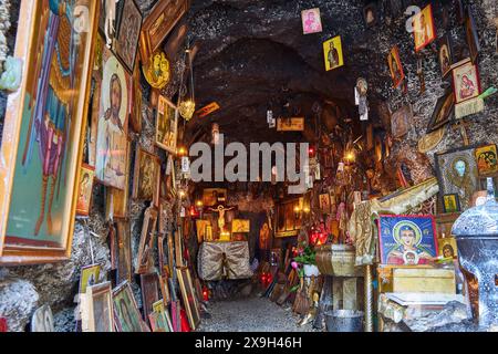 Felsenkapelle, Erzengel Michael Panormitits, Eine Höhle voller orthodoxer Ikonen und Gemälde, beleuchtet von warmen Kerzen, mit einem religiösen und spirituellen Stockfoto